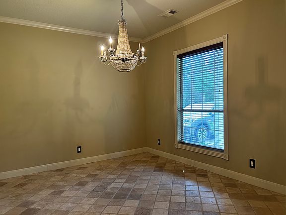 formal dining room which opens to the living room and kitchen through large arched doorways