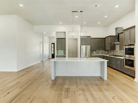 The chef-ready kitchen has stainless steel appliances and stunning wood cabinetry.