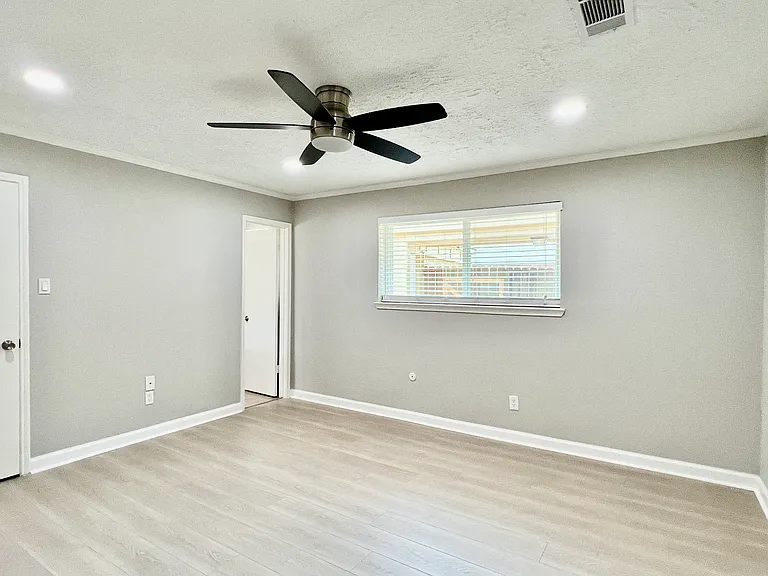 Bright and airy master bedroom featuring new windows, recessed lighting, & a ceiling fan, and a spacious walk-in closet.