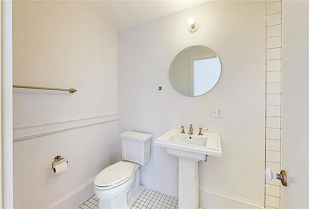 Renovated bathroom with white pedestal sink and tile flooring.
