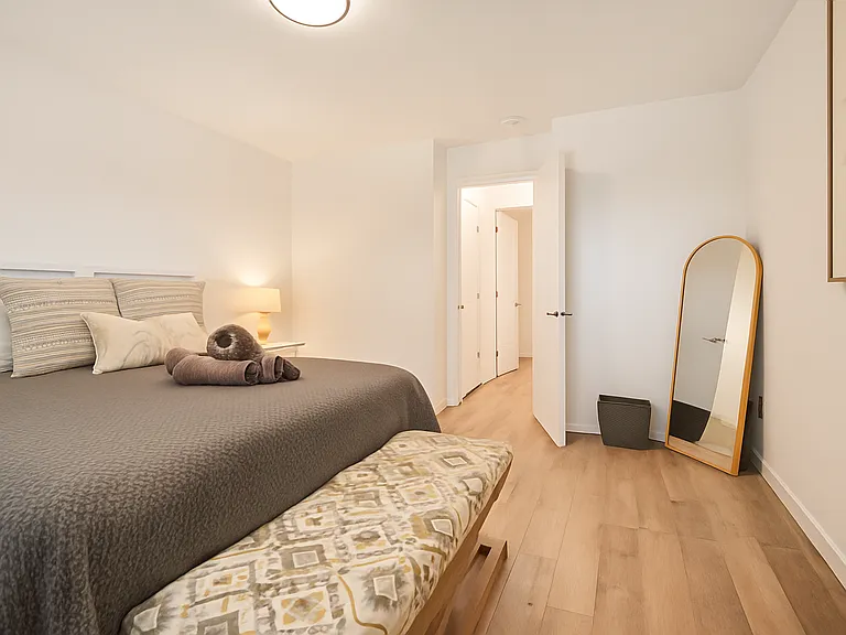 Relax in this inviting queen bedroom, complete with warm lighting, a plush bench, and a full-length mirror to make you feel right at home.