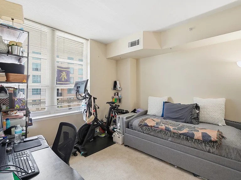 Bright secondary bedroom with large windows and flexible living space