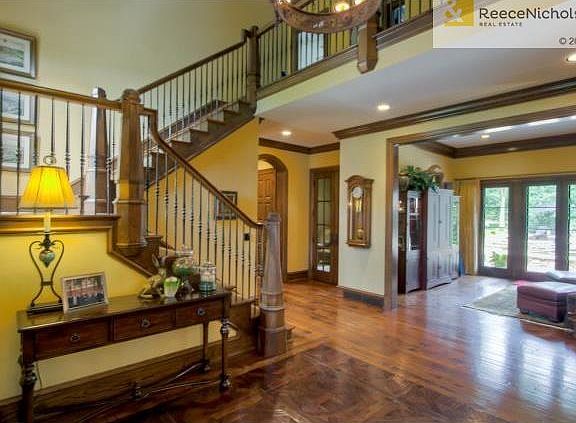 Entry with inlay hand cut and scraped wood floor, wrought iron s