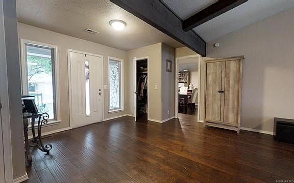 Looking at the front door and coat closet from the bedroom hallway - past the coat closet is the formal dining room