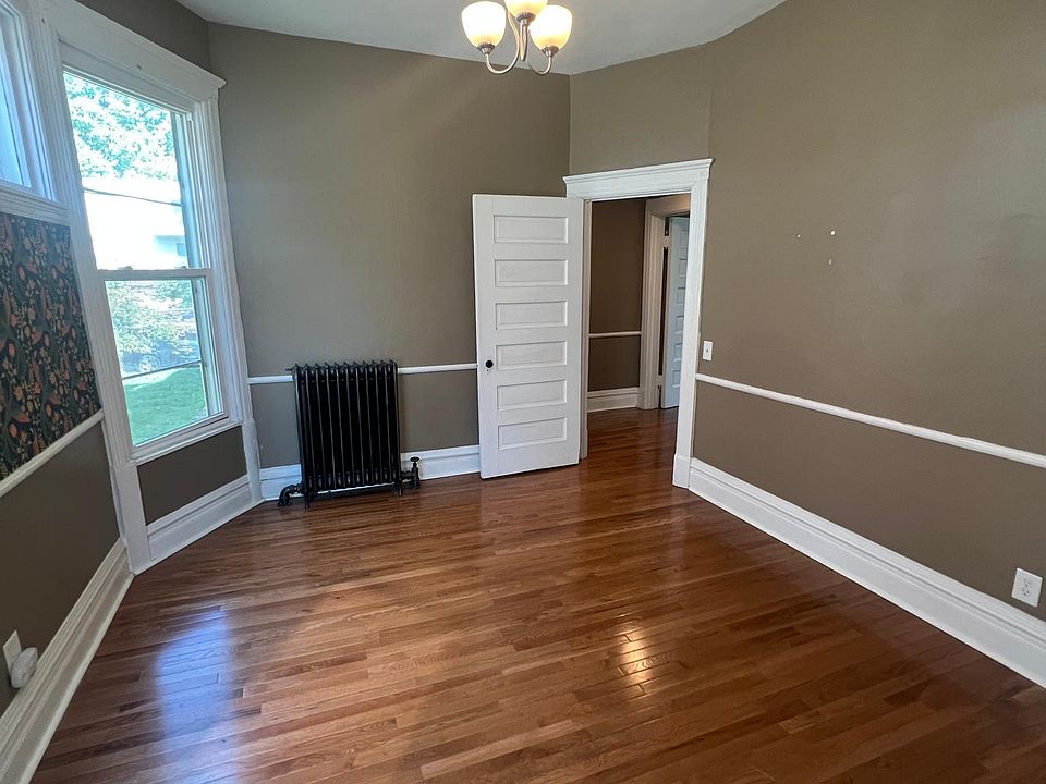 Large dining room with Built-in mirrored bar for storage and entertaining, plus 10 foot ceilings and new oak hardwood floors; tons of natural light