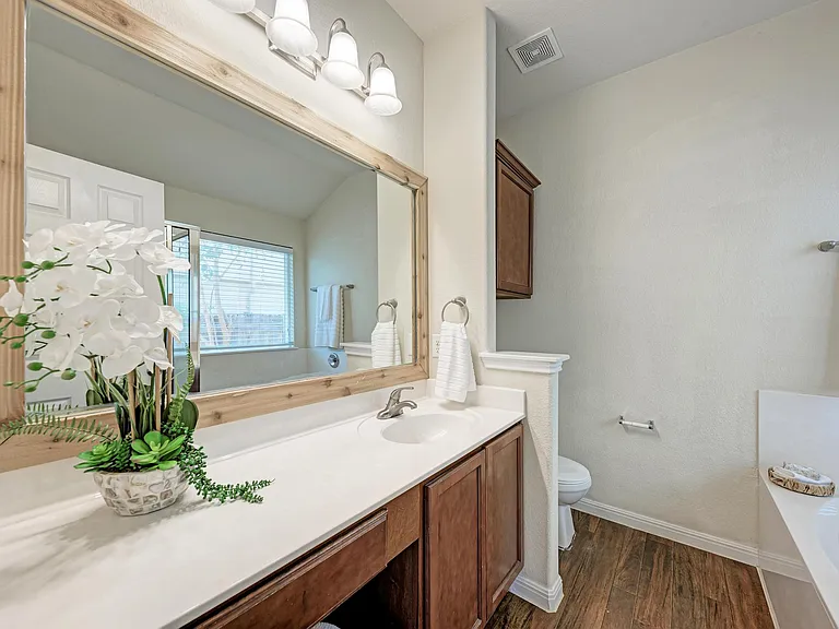 Primary bathroom with abundant counter space and area for a chair to do makeup.