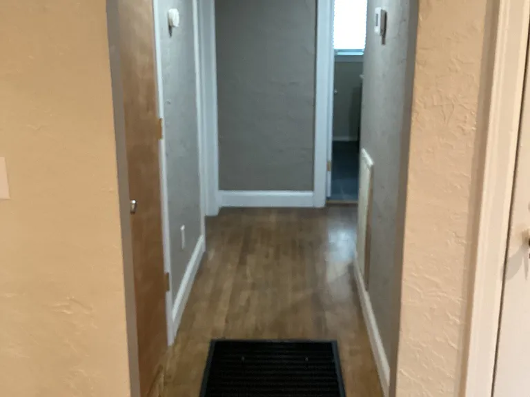 Hallway to bathroom and bedrooms. Floor furnace was removed and sealed.