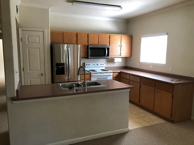 Open concept kitchen with tons of cabinet storage, pantry and all newer appliances. Kitchen window overlooks dog park area.
