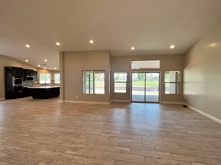 A great room greets you as you enter this home with a wall full of windows and a peaceful view of the golf course