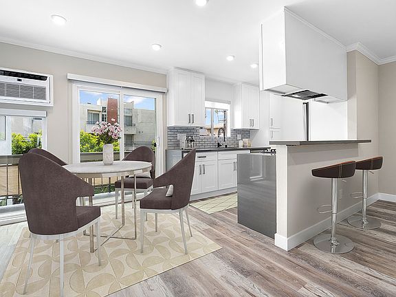 Hardwood floored dining room near bar seating in kitchen.