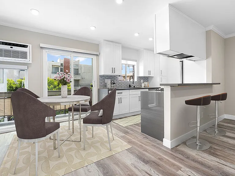 Hardwood floored dining room near bar seating in kitchen.