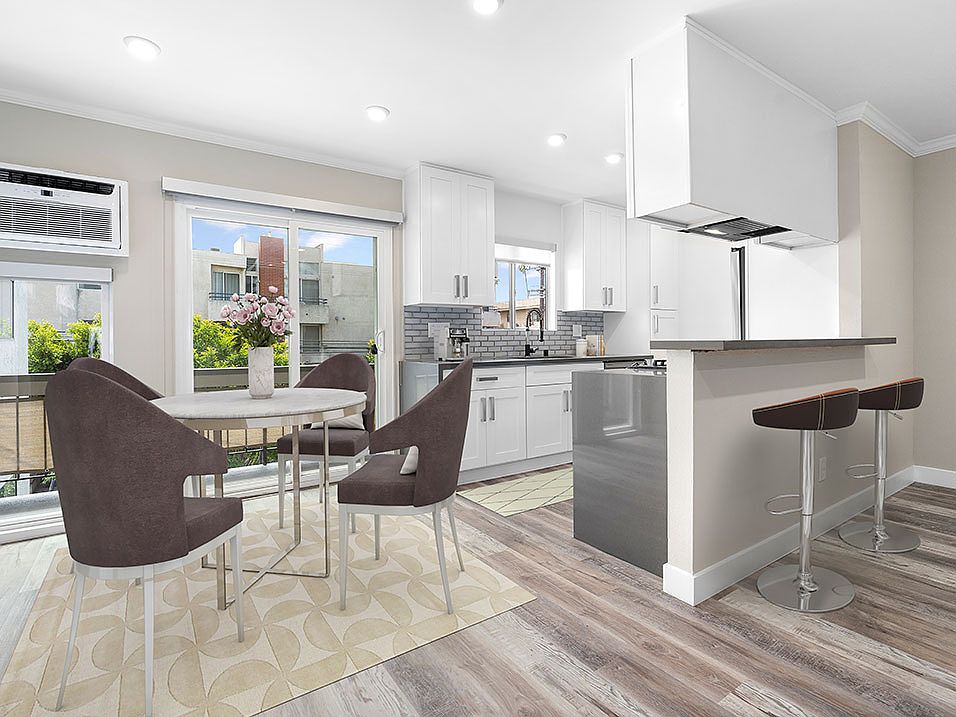 Hardwood floored dining room near bar seating in kitchen.