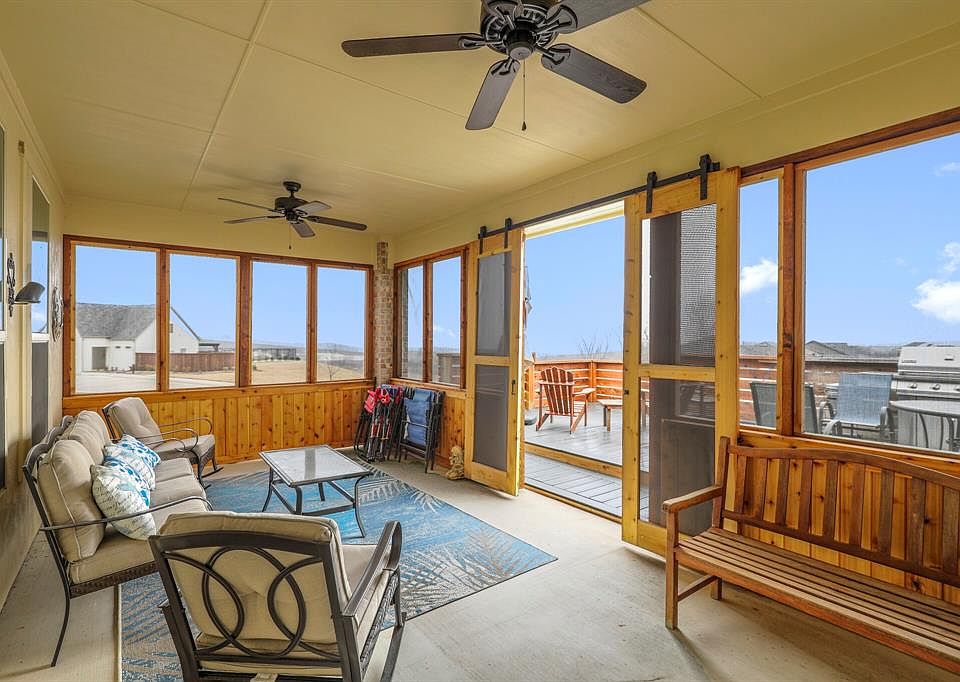 Enjoy morning coffee or evening cocktails in this screened-in sunroom with barn doors or on the Trex deck with lakeview!
