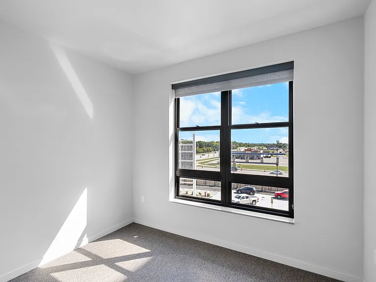 Bright and airy room with a large window offering impressive cityscape views and abundant natural light. Bright and airy room with a large window offering impressive cityscape views and abundant natural light.