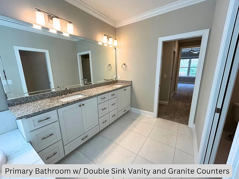 Primary bathroom with double sink and granite counters