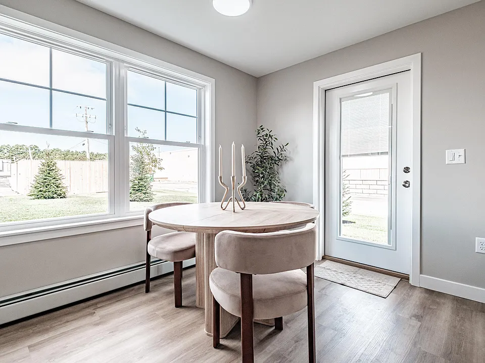 Designed for everyday living, this bright and inviting space features large windows, comfortable finishes, and an open dining area that feels right at home.