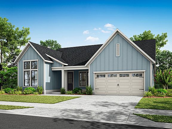 A two-story house with a gray exterior, a gabled roof, and a garage door sits in a well-landscaped y