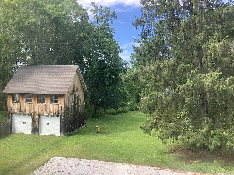 View from Kitchen & Bedroom 1, overlooking parking area & back yard. (Garage/barn is owner storage only).