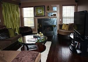 Dark, wide hardwood flooring with custom fireplace and mantle