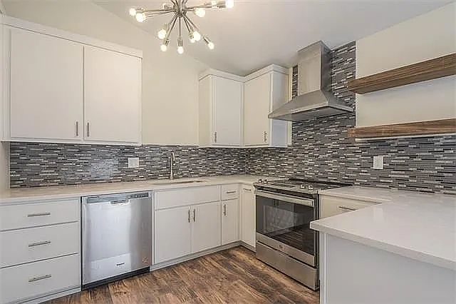 New kitchen with stainless appliances and open shelving and contemporary lighting