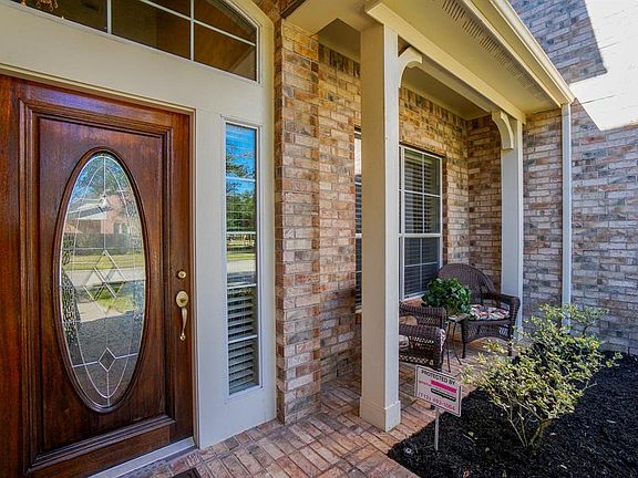 Inviting front porch is surrounded by stone and brick elevation
