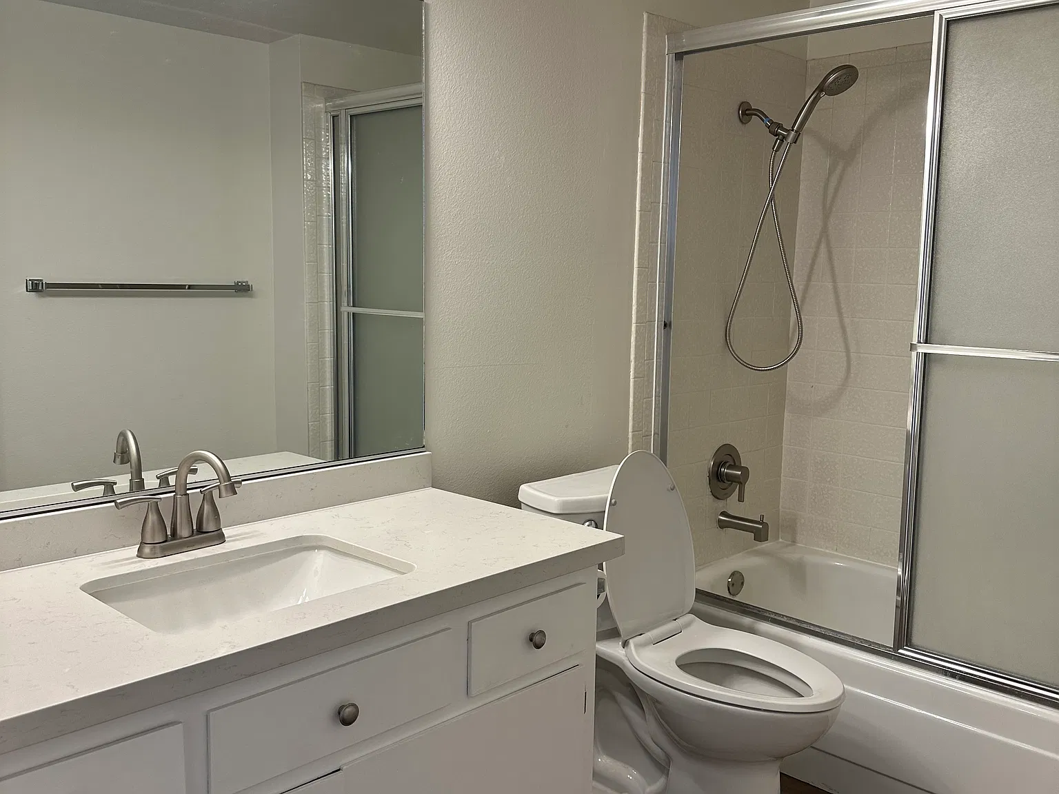 Bathroom off hallway with bathtub and shower fixture