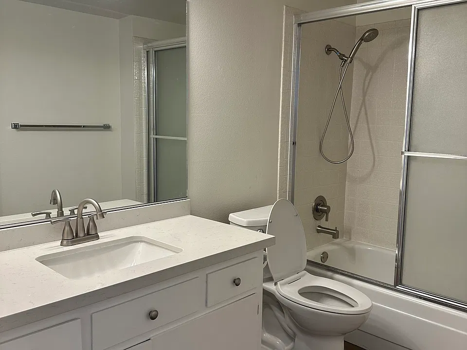 Bathroom off hallway with bathtub and shower fixture
