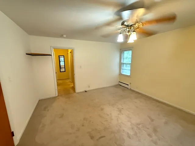 master bedroom looking back to tv stand and hall to two smaller bedrooms.