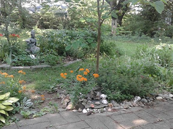 Stone patio. Large private backyard with flowers.