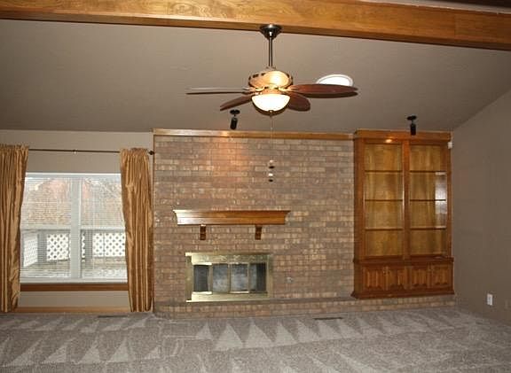 Living Room Bookshelf, Beam Ceiling, and Skylight with Ceiling Fan