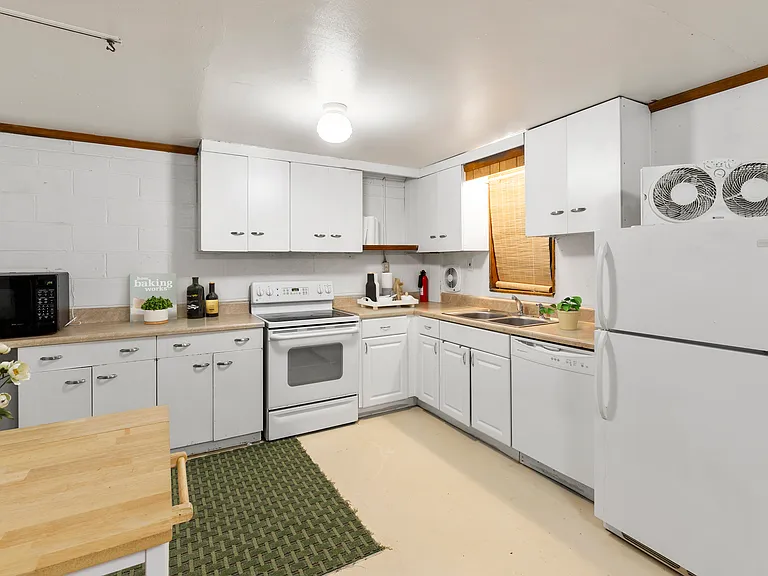 Kitchen with electric range/oven, dishwasher, microwave and refrigerator.
