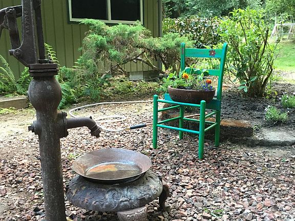 Fun landscaping with flagstone patio fire pit in upper yard.