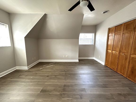 Bedroom new flooring, sleek ceiling fan, and 2 closets for ample storage.