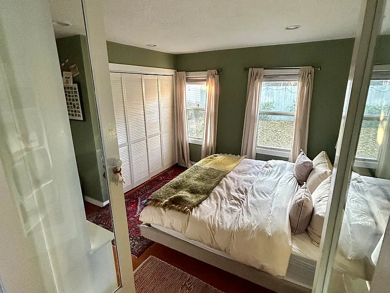 Primary bedroom on back of house; two windows that look into garden.