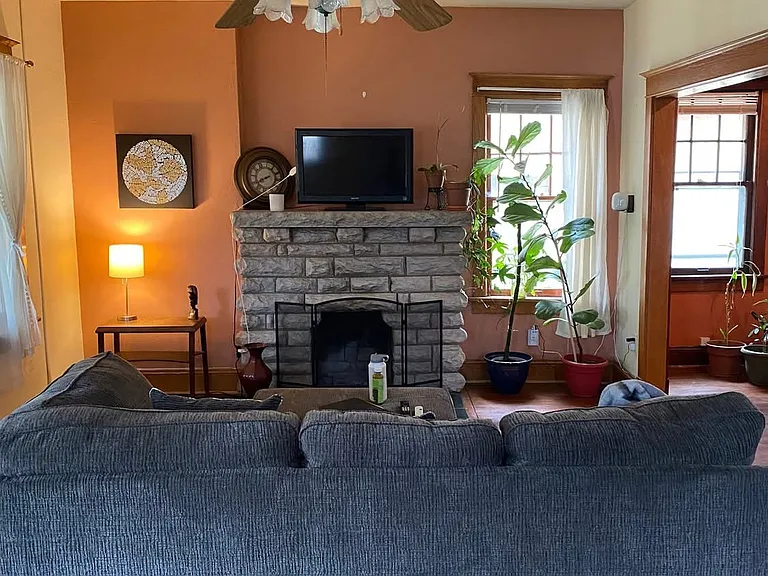 Large living room with beautiful hardwood floors and warm, earthy tones