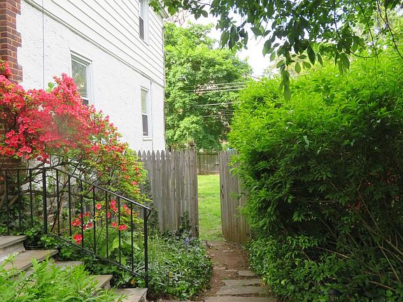 Through the gate is the fenced backyard. The backyard is private. The backyard is not visible from the street as the fence blocks the view.