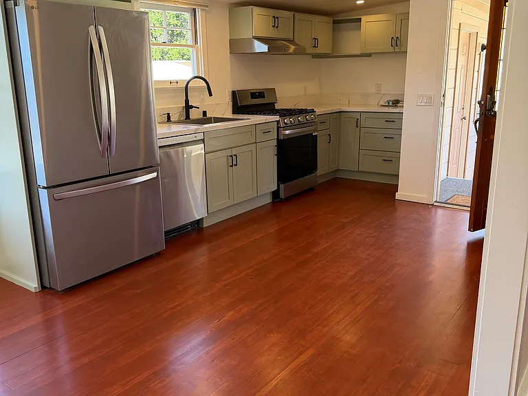 Kitchen and front door. Brand new premium appliances including a dishwasher.
