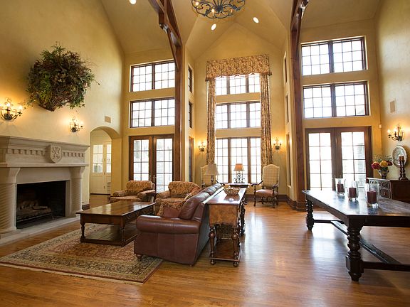 Great Room is enhanced by oversized cast stone gas fireplace, gorgeous iron wall sconces, arched walk thrus and furniture niches.