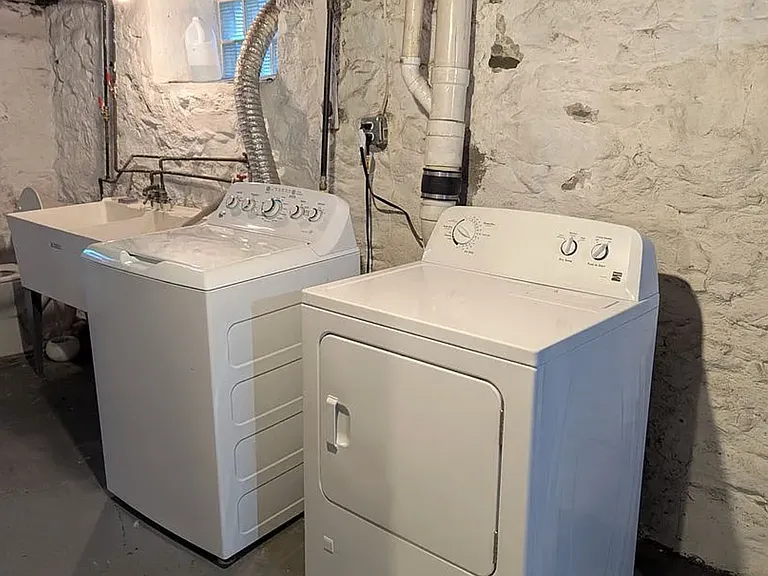 Basement level features a Washer & Dryer & Work Sinks & new Toilet (full basement not featured here, but available upon request _dry, spacious and good for short or long term storage, includes built-in, old-school work bench table and shelving