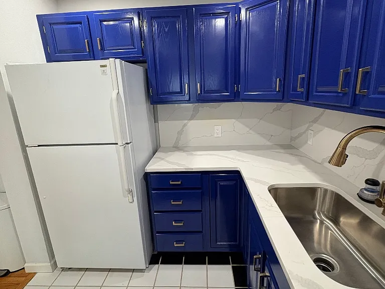 Modern kitchen with quartz countertops, stainless steel sink, and custom cabinetry.
