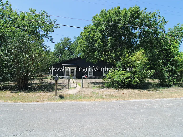 The front of the home faces Kenwood Ave and features a spacious, open grass yard