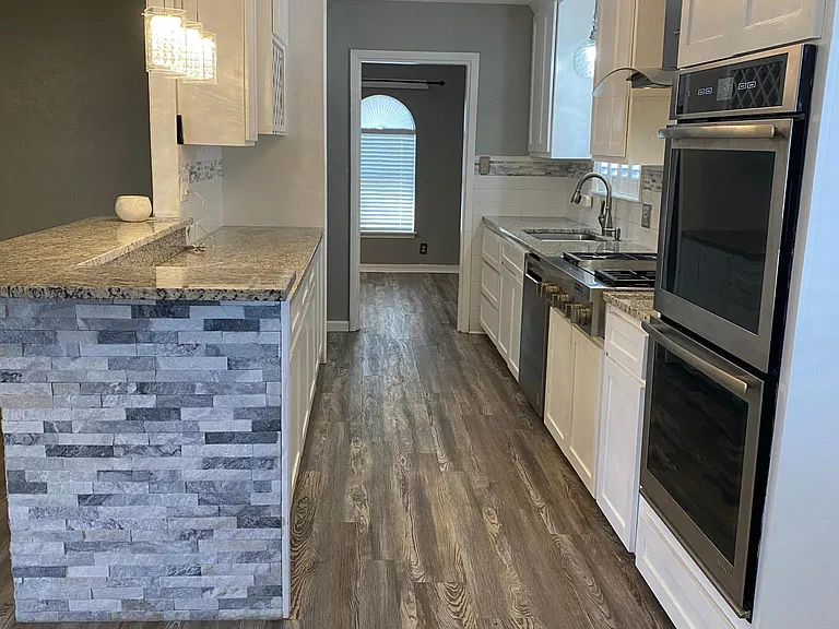 Kitchen with gas cooktop with griddle; double oven, dishwasher, wine rack