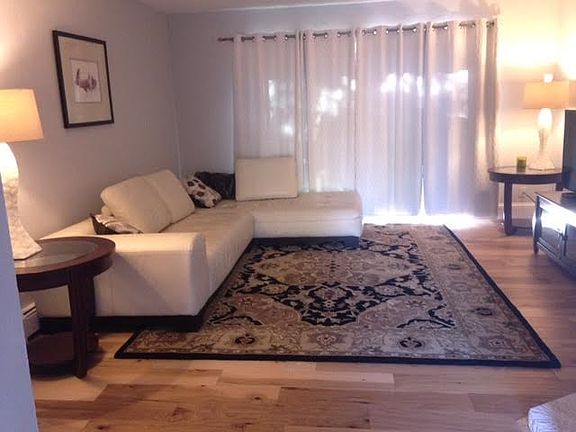 Gracious living room with white leather and hardwood; 8 foot