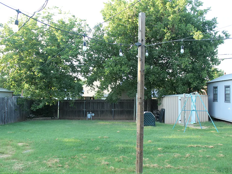 Large backyard with brown storage shed for yard/gardening supplies