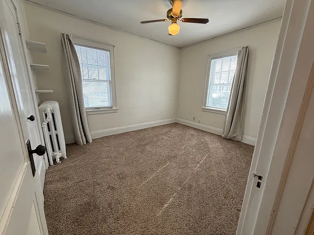 Bedroom one with ceiling fan and window AC.