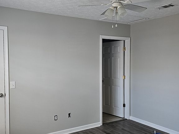 Primary bedroom with walk-in closet, ceiling fan and double windows. Private bathroom.