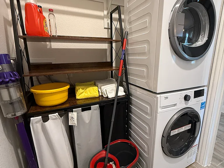 Loundry room with Washer, Dryer, Dyson vachuum cleaner and cleaning stuf.