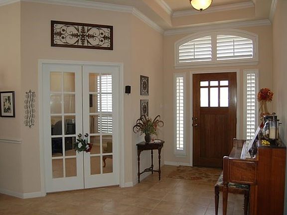Entry with private office in front of home. Attention to detail with crown molding and plantation shutters.