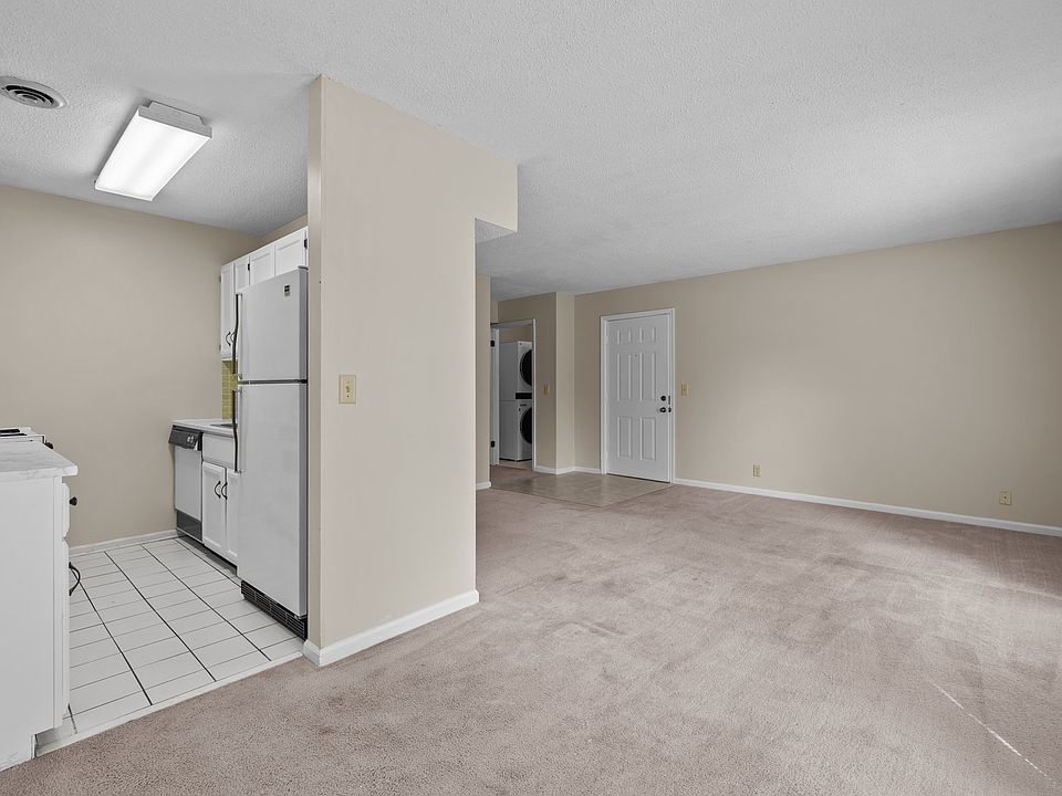 Open living/dining area. Each apartment is somewhat different. This apartment does not have carpet and has dark wood kitchen cabinets.