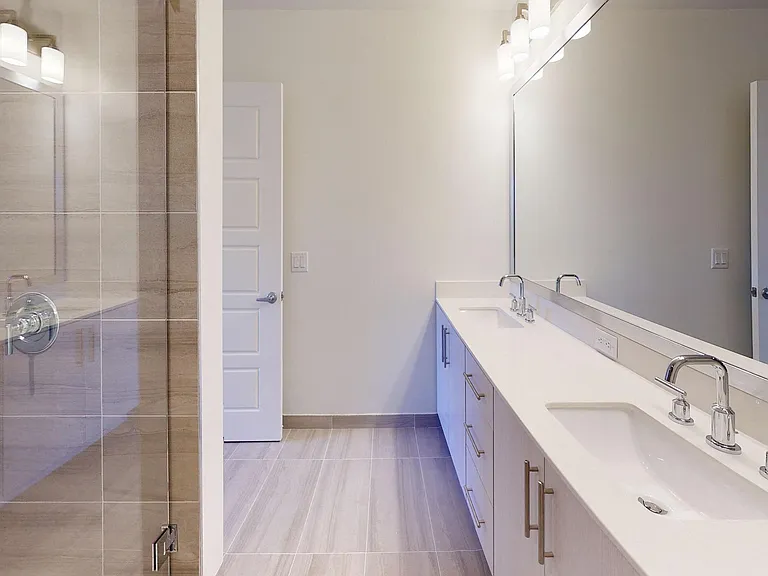 Spacious en-suite master bath with custom-framed mirror.